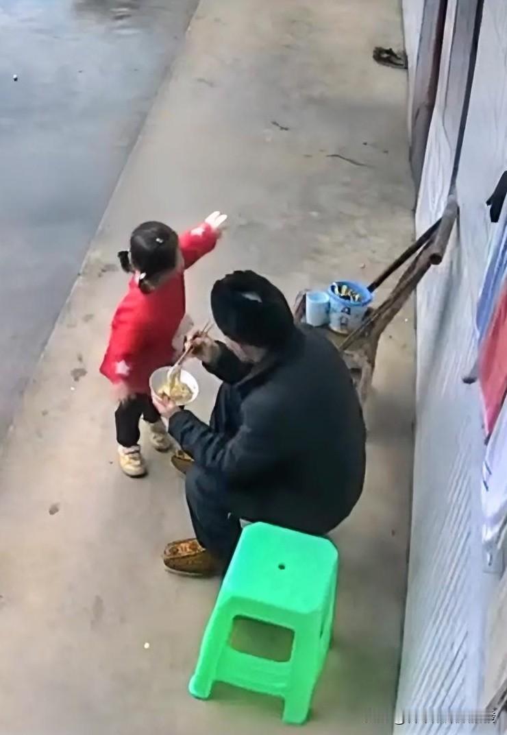 爷爷独自坐在前檐下边吃面条，小孙女看到后急忙跑了过来，用稚嫩的声音对着爷爷一字一