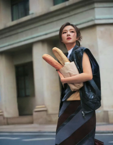 无袖皮质马甲叠搭几何印花半身裙，利用皮革的酷飒感与裙装的柔美碰撞，平衡专业性与个