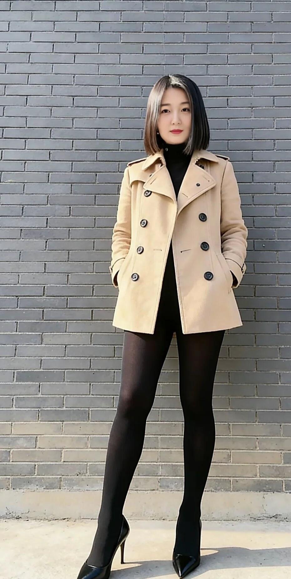 卡其色风衣撞上灰砖背景，内搭黑色高领与黑丝高跟，把秋日的干练与优雅揉进街角的光影