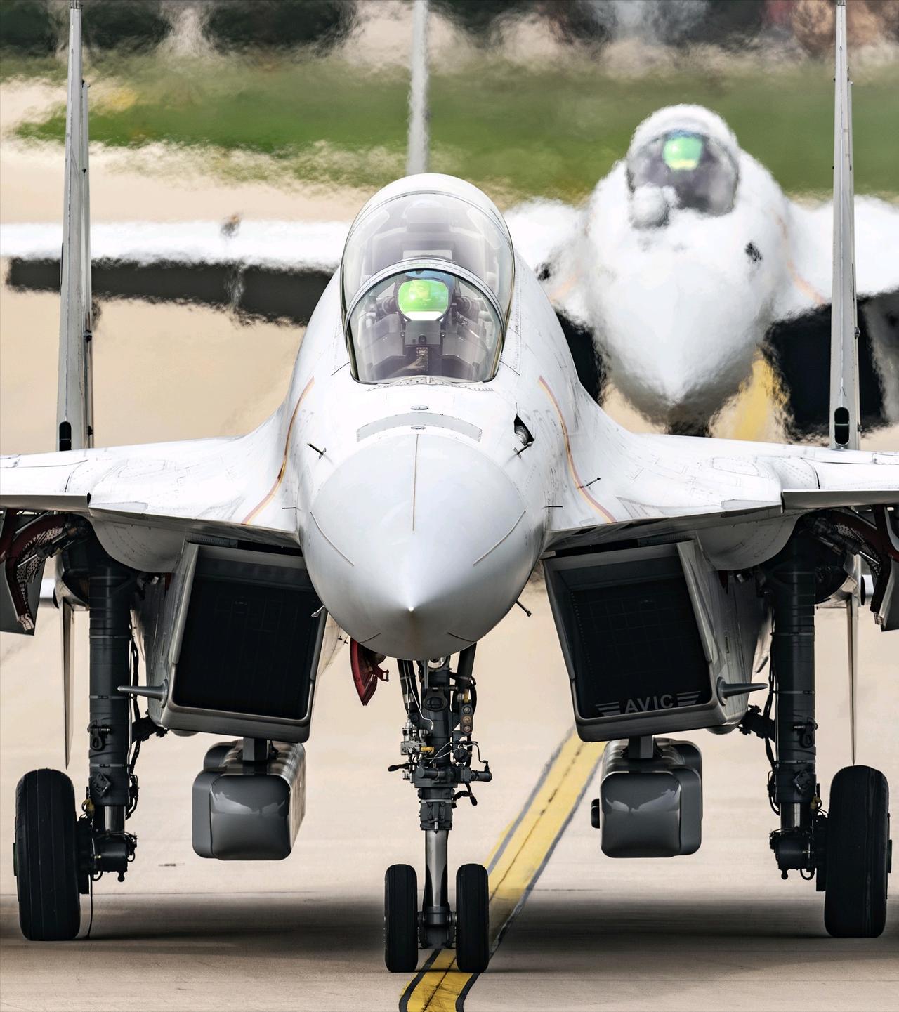 歼-15电的分辨特征，双轮的前起落架，没有光电头的机头，进气道下方的电子战吊舱，