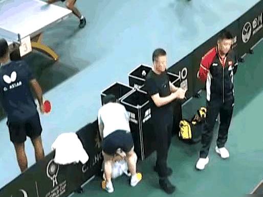 莎莎收拾东西时掉了一个东西在地上被站旁边的厨子不小心踩到了。刘国梁颁奖时