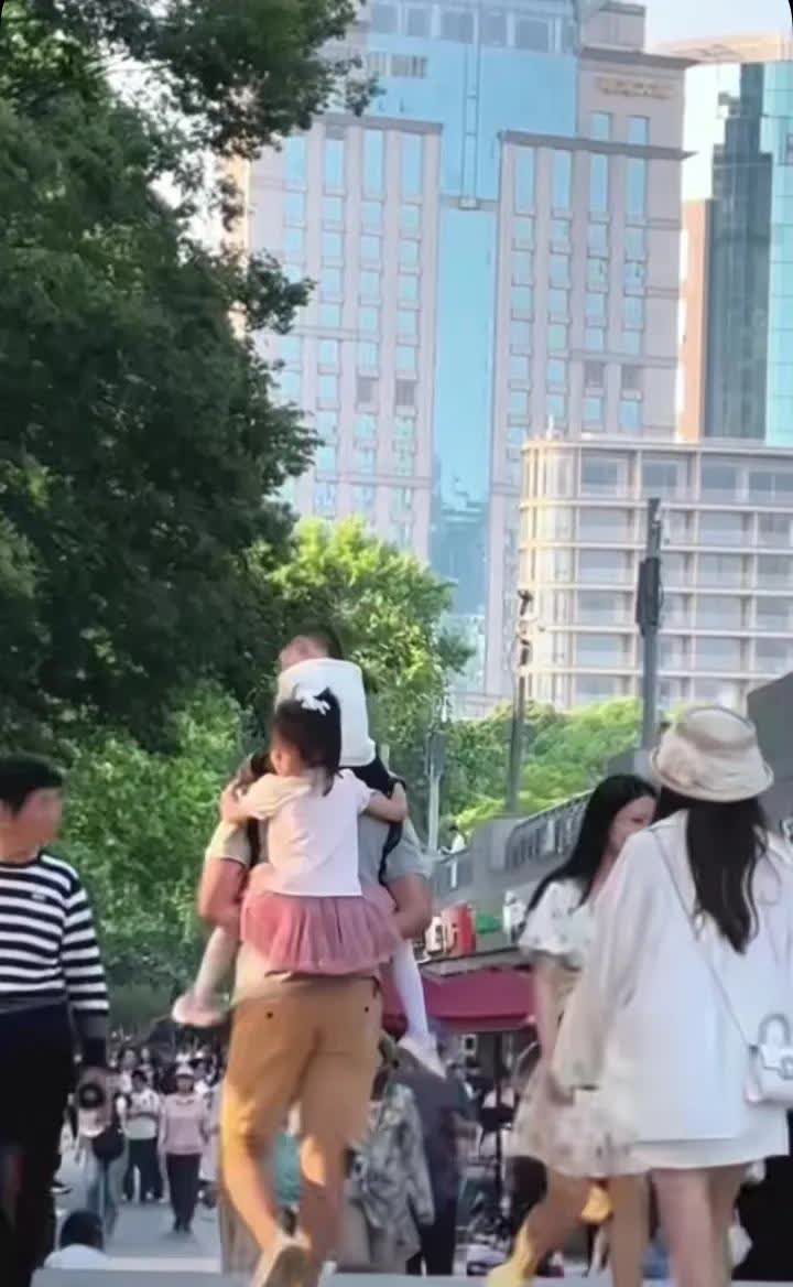 如果画面中背着两个孩子的人是妈妈的话，评论区会是怎么样呢？大概率是会充满对妈妈的