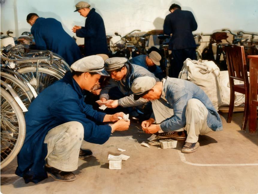 这张拍摄于1947年的照片，是上海电话公司的工人们蹲在堆满自行车的车间里，围着散