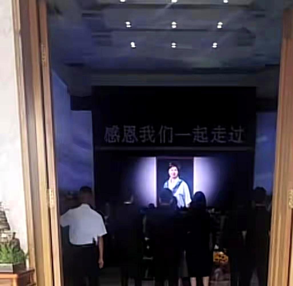 没想到，敬一丹的遗像竟是一张蓝色休闲服加围巾的生活照，一点不职业。在殡仪馆那一