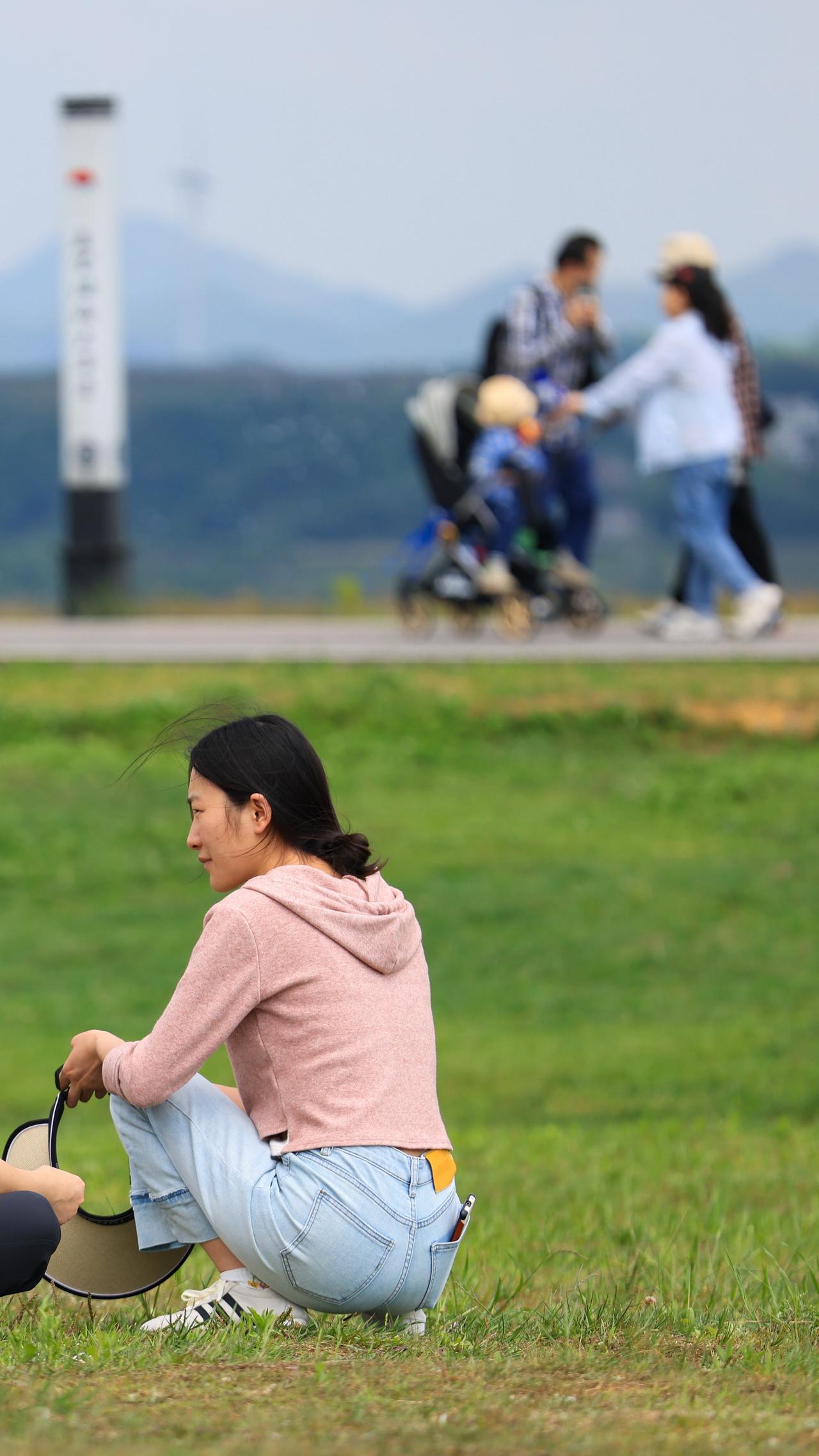 组图｜户外草地上，有人定格镜头里的明媚，有人静享风里的松弛，也有人在手机屏幕前藏