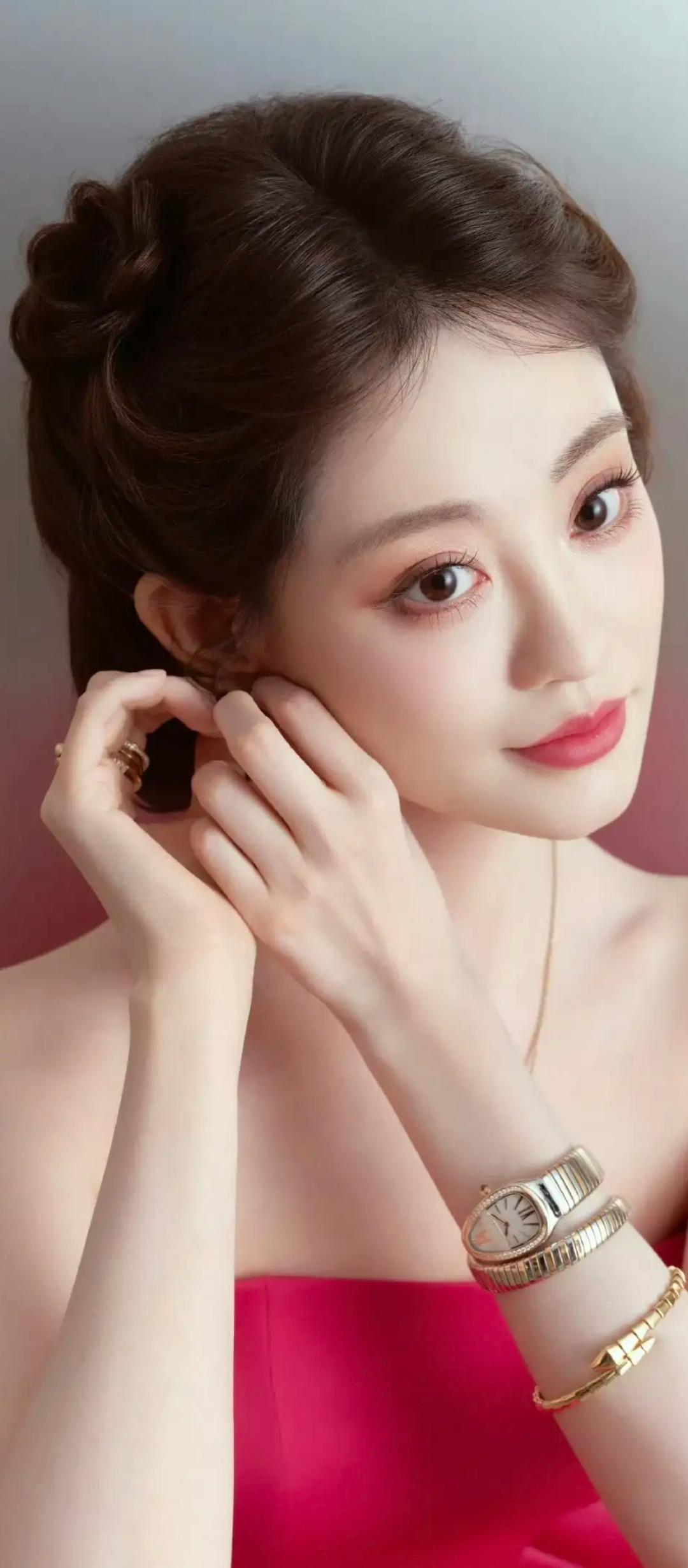 玉手轻抚耳畔，金饰映照容颜。