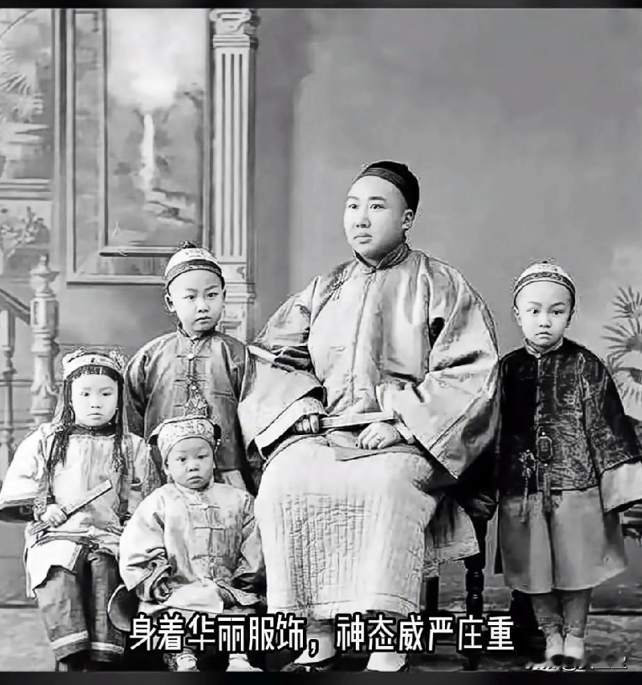 1907年的一张老照片，一位13行的商富巨头，身着华丽服饰，神态威严庄重，身旁围