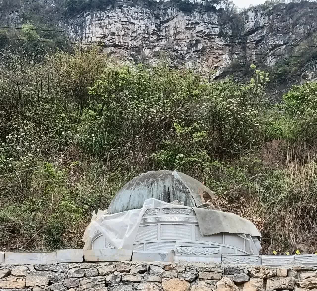 广东，一名女子回乡扫墓时，偶然发现一座无碑无文的坟墓，坟头上还覆盖着几块塑料布。
