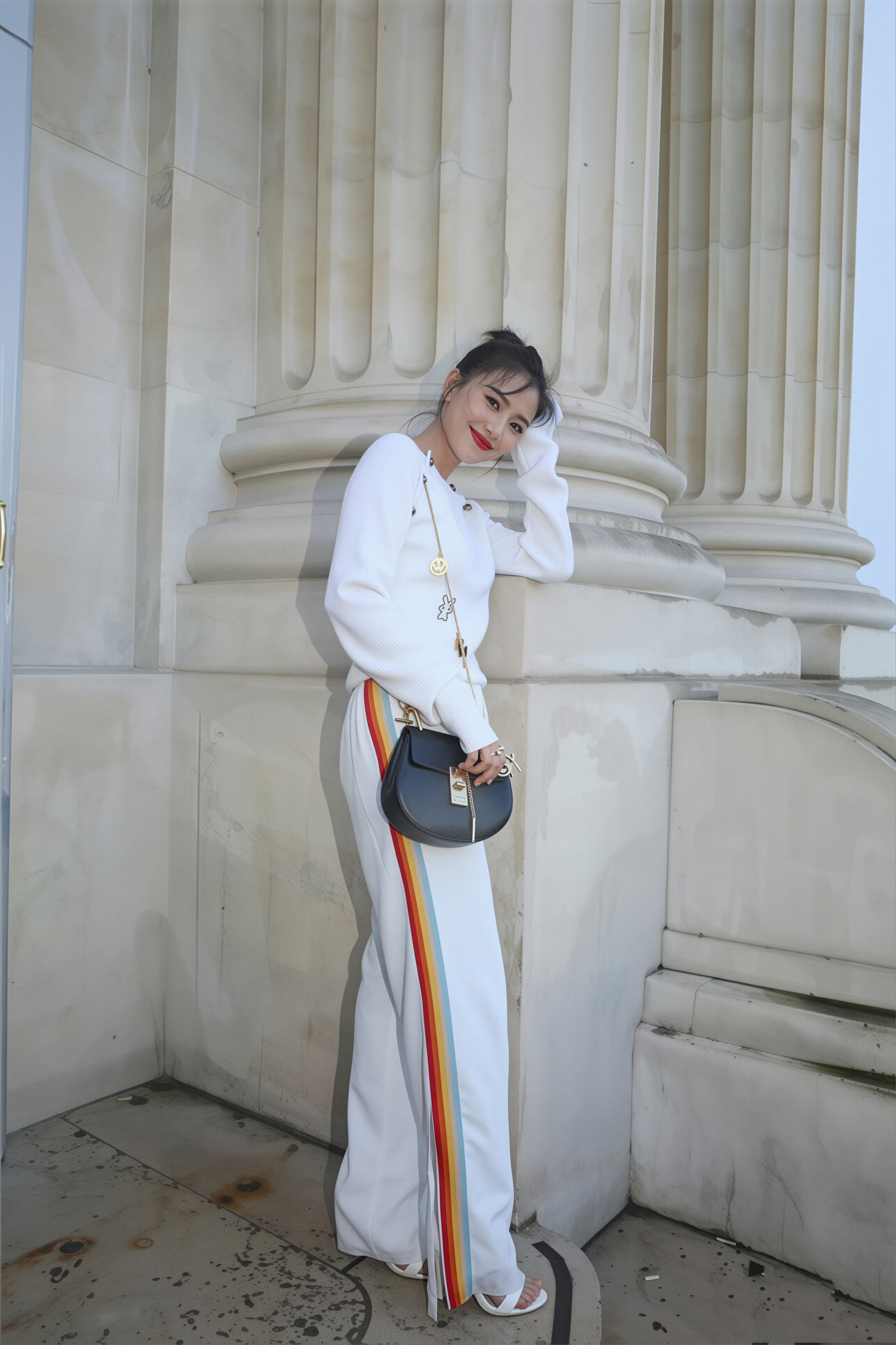 高圆圆以高丸子头搭配白针织衫与彩虹条纹阔腿裤亮相，造型清爽灵动，松弛感拉满。无