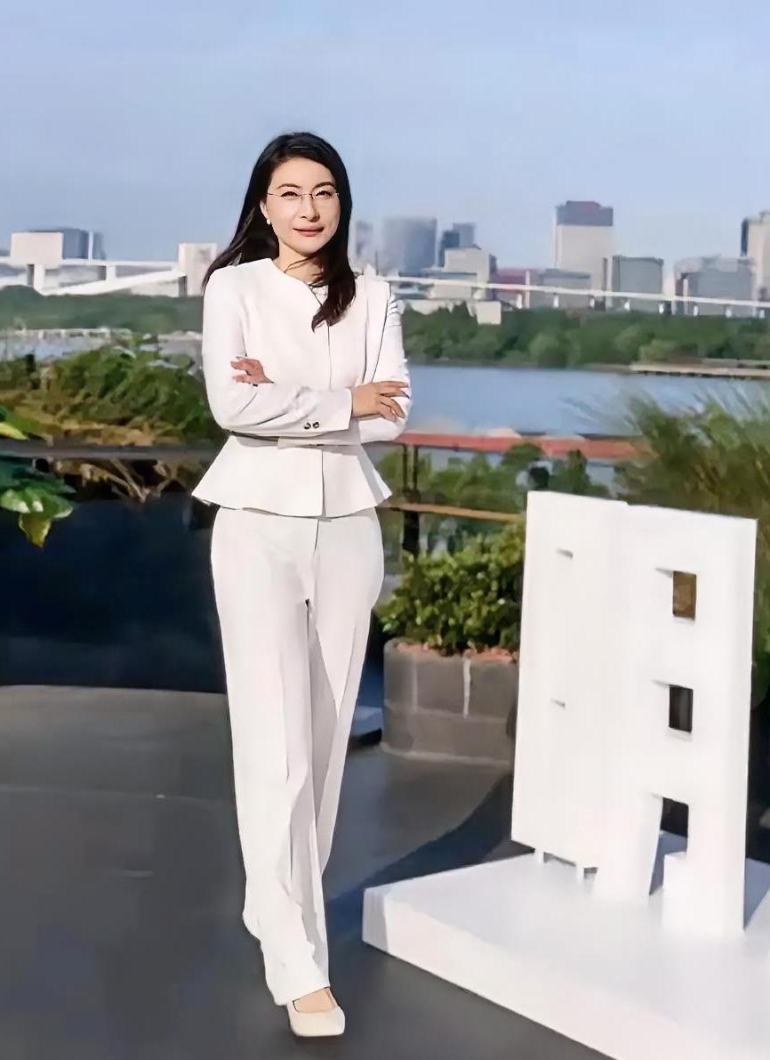 郭晶晶最有风度和魅力的一张美照。美艳和气质超凡。黑色长发，金丝眼镜，白色套装，清