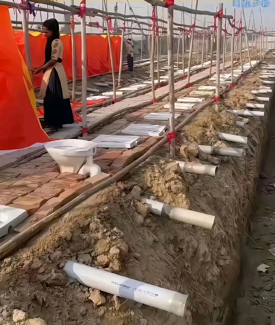 印度的露天公厕是真让人跌破眼镜，就是地上挖个大深坑，中间简单隔一下当俩蹲位，连个