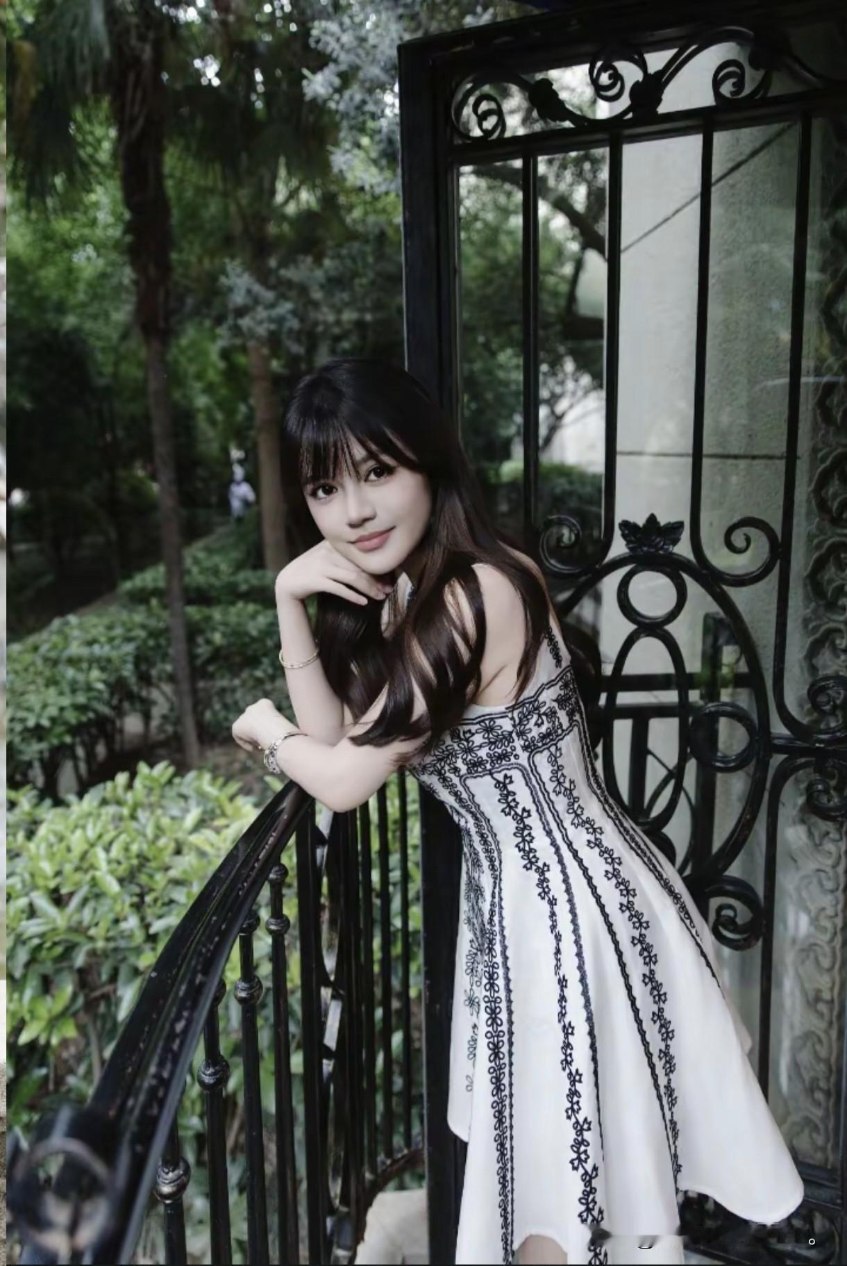 优雅白裙少女，倚栏微笑，绿意盎然背景，清新自然。湖边白裙少女梦幻白裙少女白裙