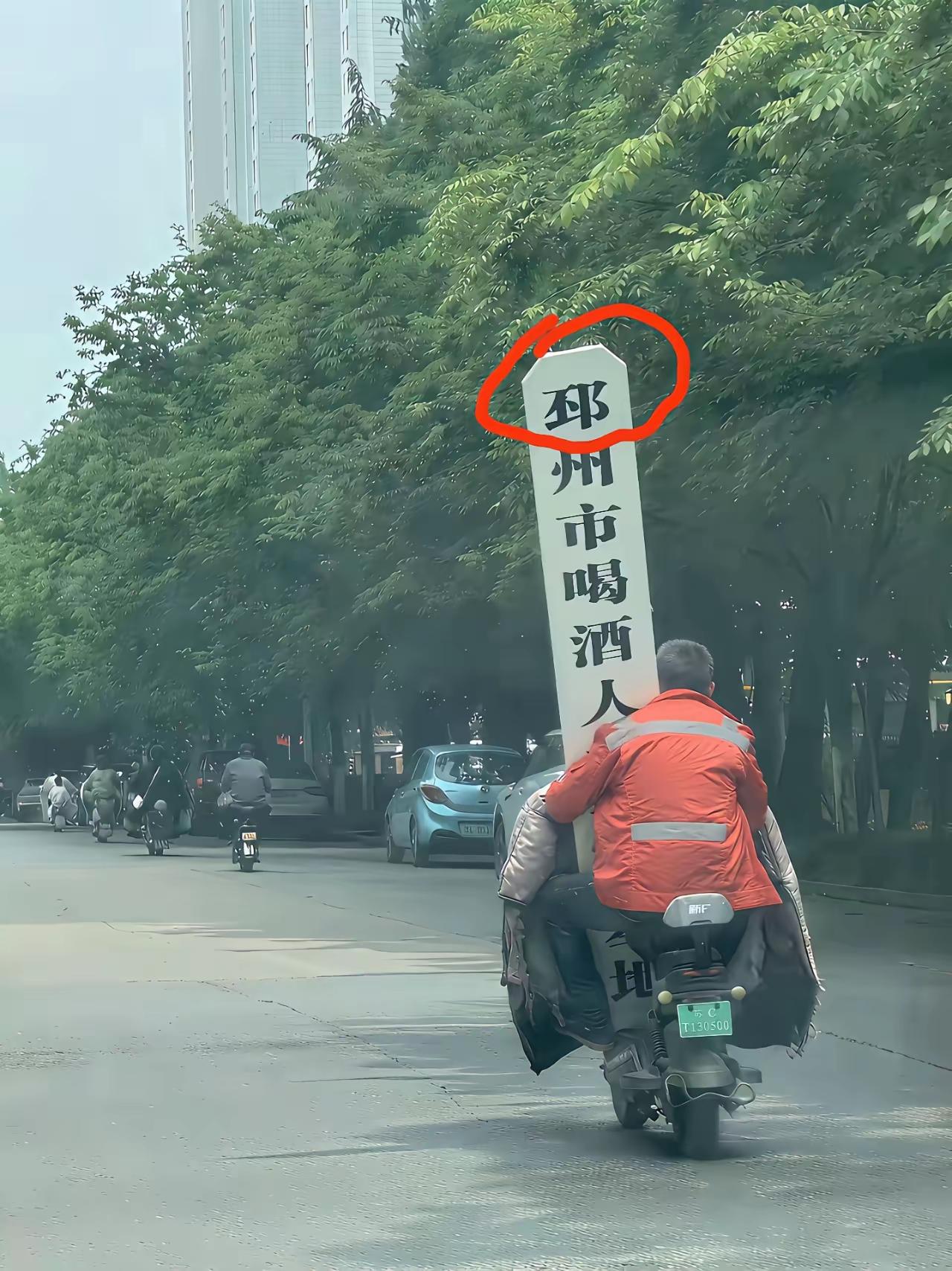 邳州人真是露大脸了这位在大街上兴冲冲扛着“邳州市喝酒人才培训基地”的牌