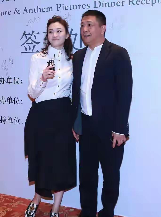 最近行业聚会上，李小冉和老公徐佳宁的合影里，47岁的她穿件白衬衫配黑色半身裙，半