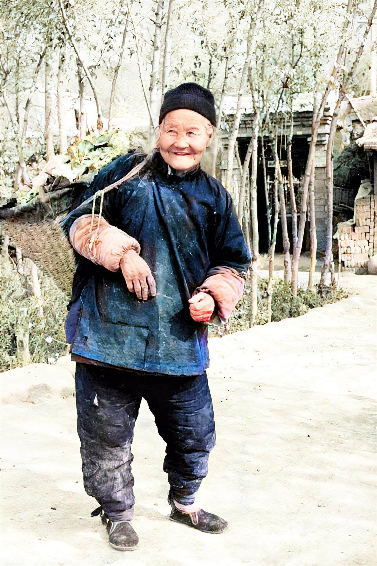 1987年，青海西宁乡村的一个老奶奶，头顶布帽，穿着厚实偏襟棉衣和扎腿棉裤，戴