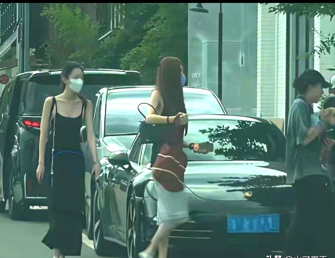 窦靖童怀里抱着爱犬，旁边走着穿黑色吊带长裙的李嫣。镜头一转，宋妍霏也在。她穿着黑无袖上衣搭白裙子，跟