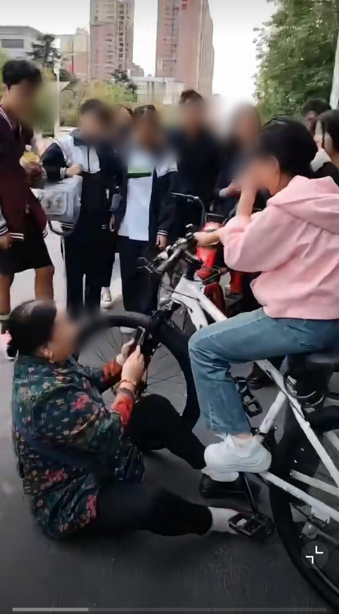 最近网上疯传一段视频：某地街头，一位老太太突然坐在地上，死死抓住一个骑自行车的十