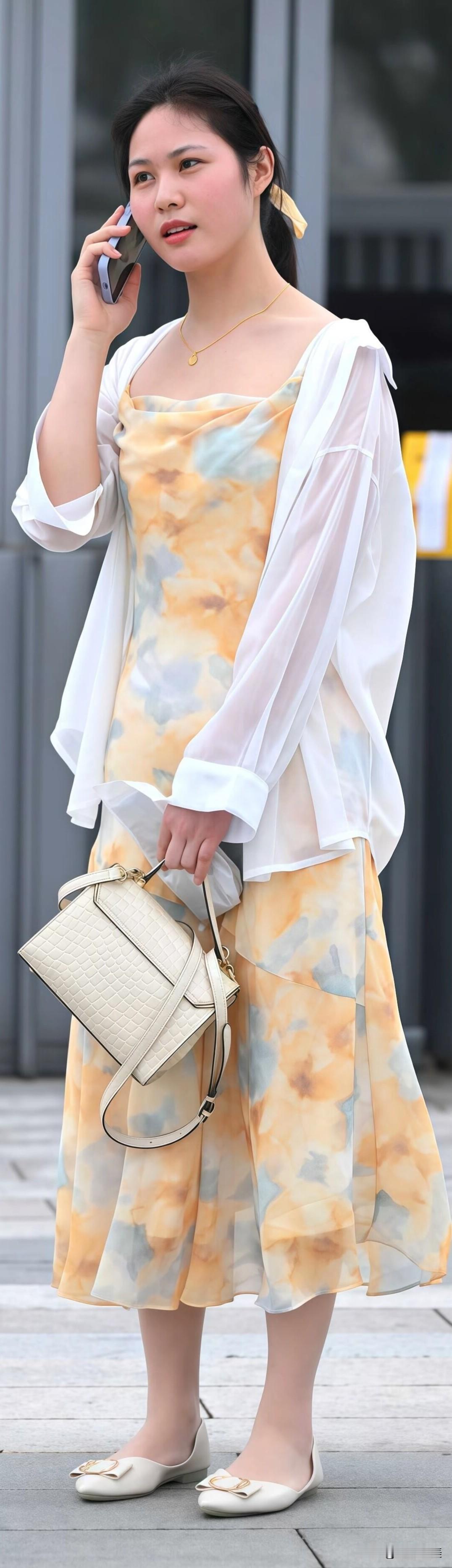 黄色扎染吊带裙自带元气，外搭一件白衬衫，防晒又有层次感。浅口平底鞋+小巧包包，日
