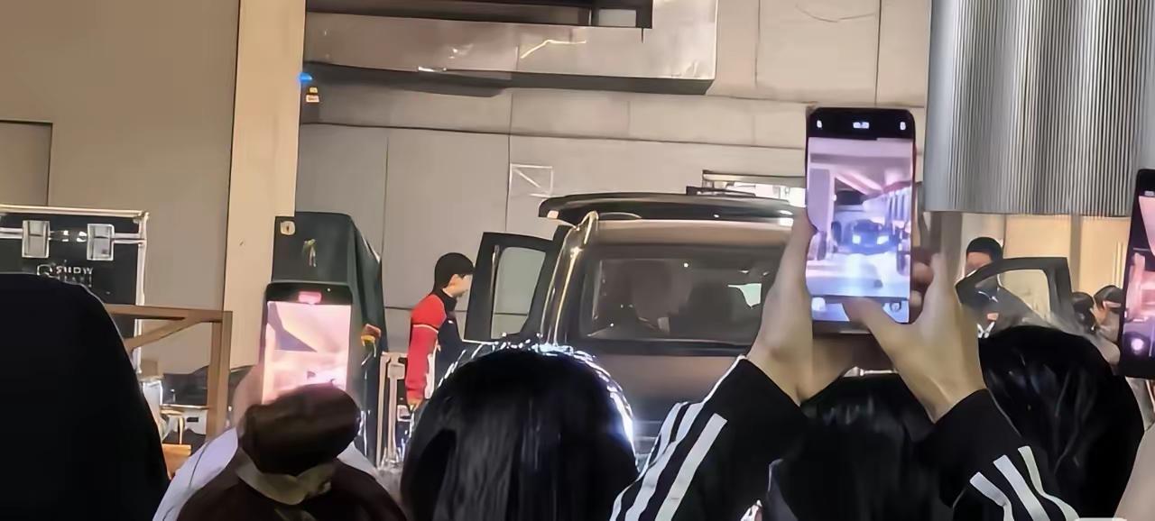 莎莎昨晚12点来到馆场准备乘车回去休息。一群粉丝围着她拍照。莎莎默默拉