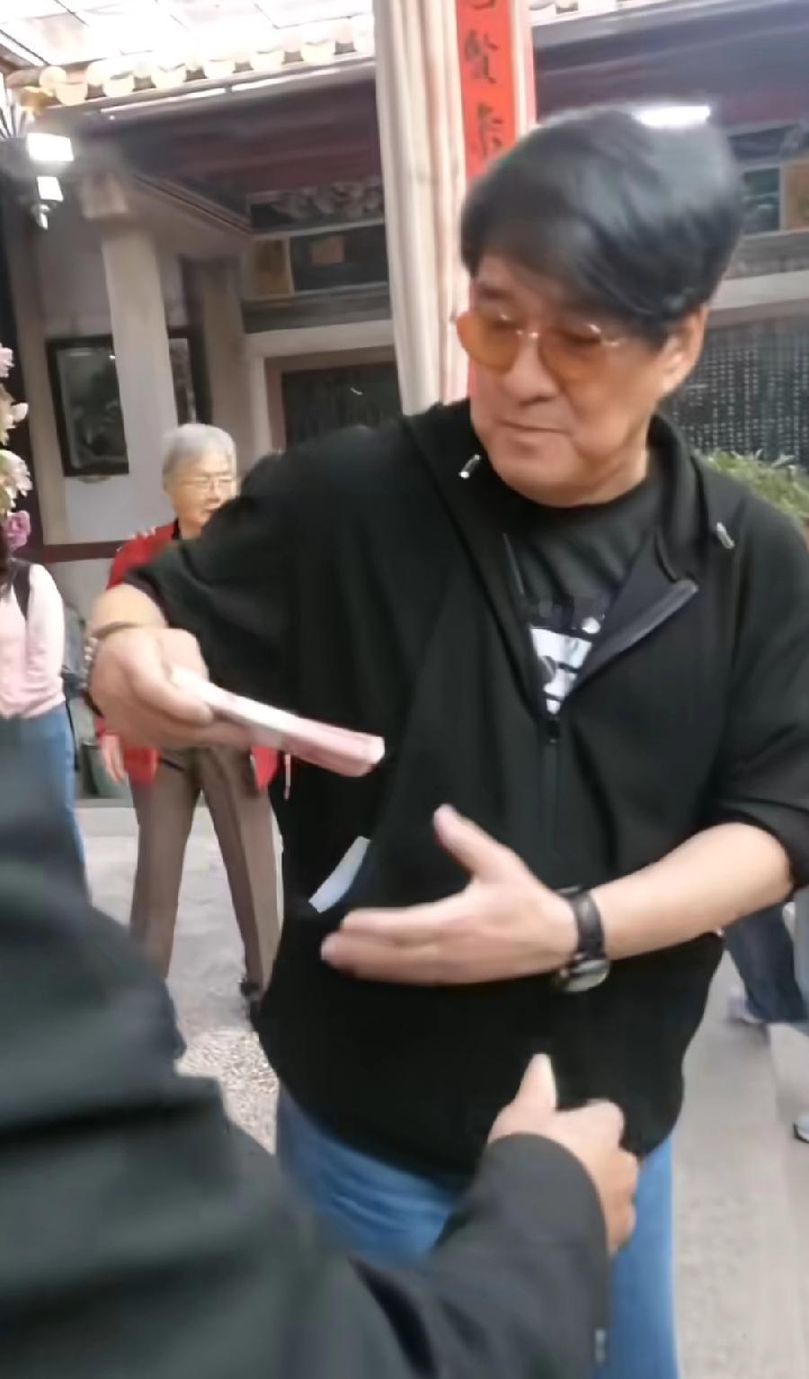 周华健回汕头老家，掏出一捆1万元现金，交给一位宗亲，感谢在祠堂举报欢迎自己的活动