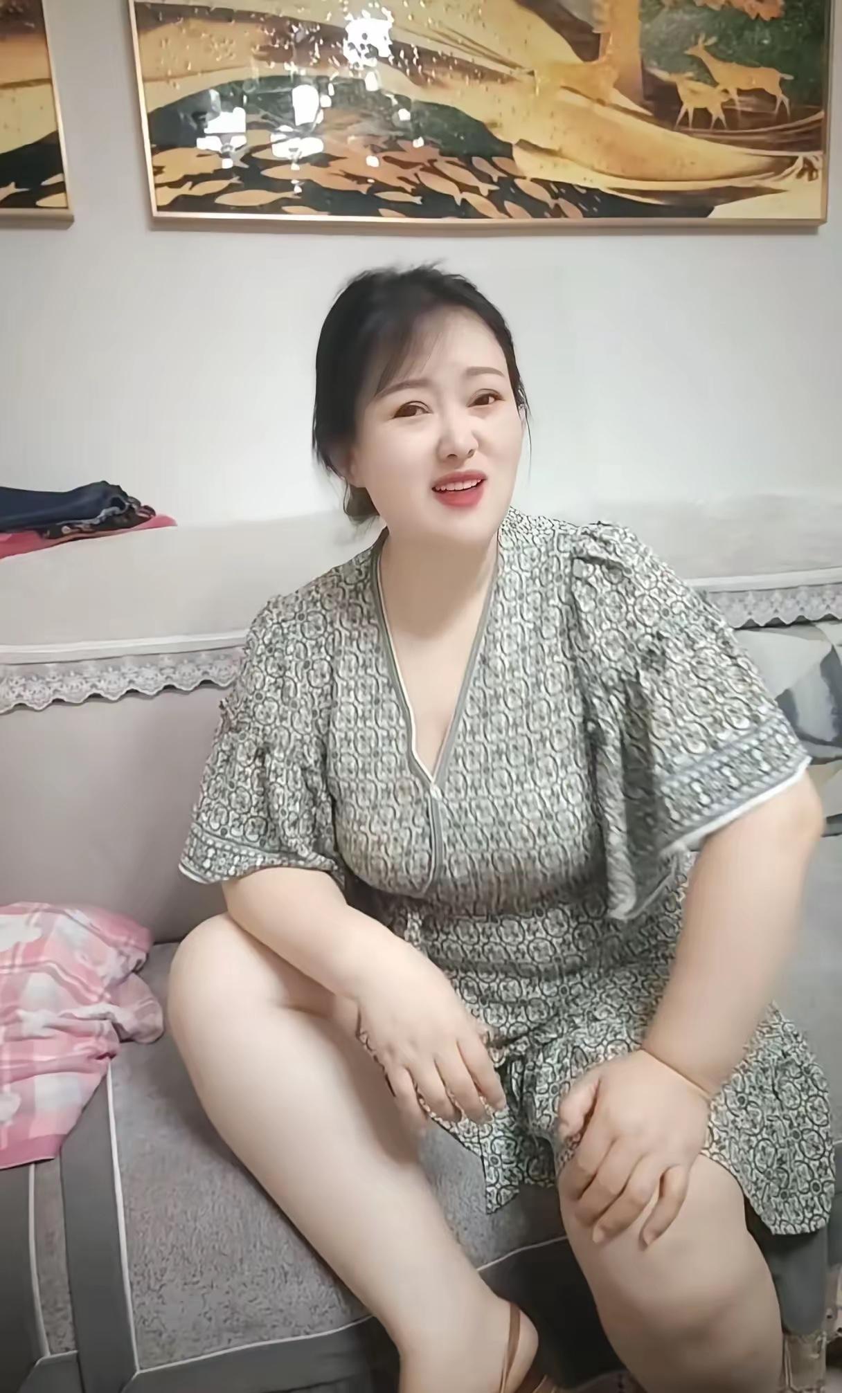 主妇的坐姿沙发之上把身安，一袭花裙映笑颜。腿间轻放玲珑手，日子悠悠心自宽。