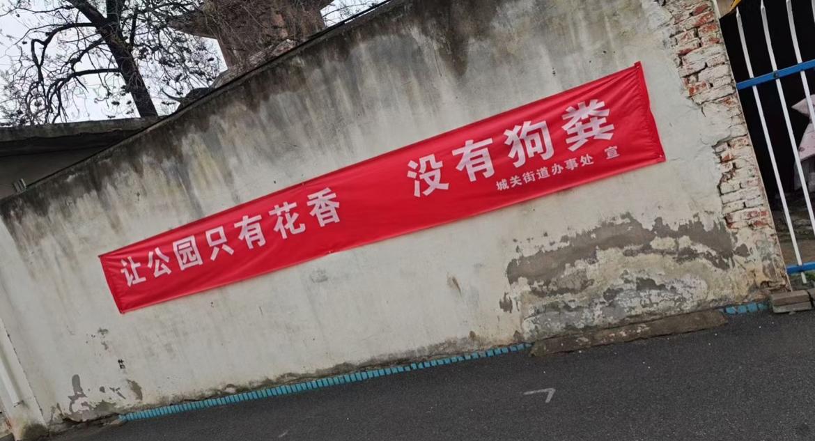 《让公园只有花香，没有狗粪》，第一次见这么接地气的条幅标语，感觉挺不错的。