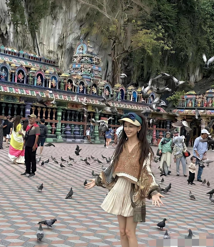 在马来西亚吉隆坡黑风洞偶遇佟丽娅的旅行路透。她一身波西米亚风穿搭，在彩色建筑