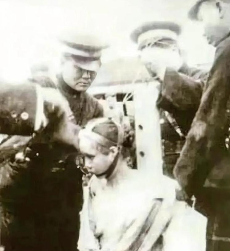 这是1927年，民国时期，“裸刑”处决的现场，镜头中跪着一名女子，旁边是几个正在