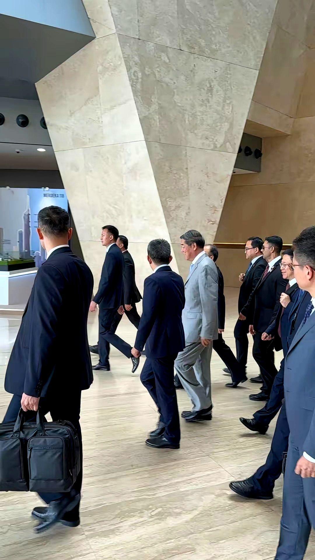 走出会场那会儿,他们没笑,也没急着上车。就那么走着,像刚遛完弯的老爷子,手插