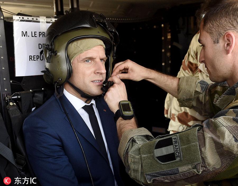 马克龙和士兵在一起，他手搭肩膀的那两个女兵一个是黄皮肤一个是黑皮肤。那些女兵笑得