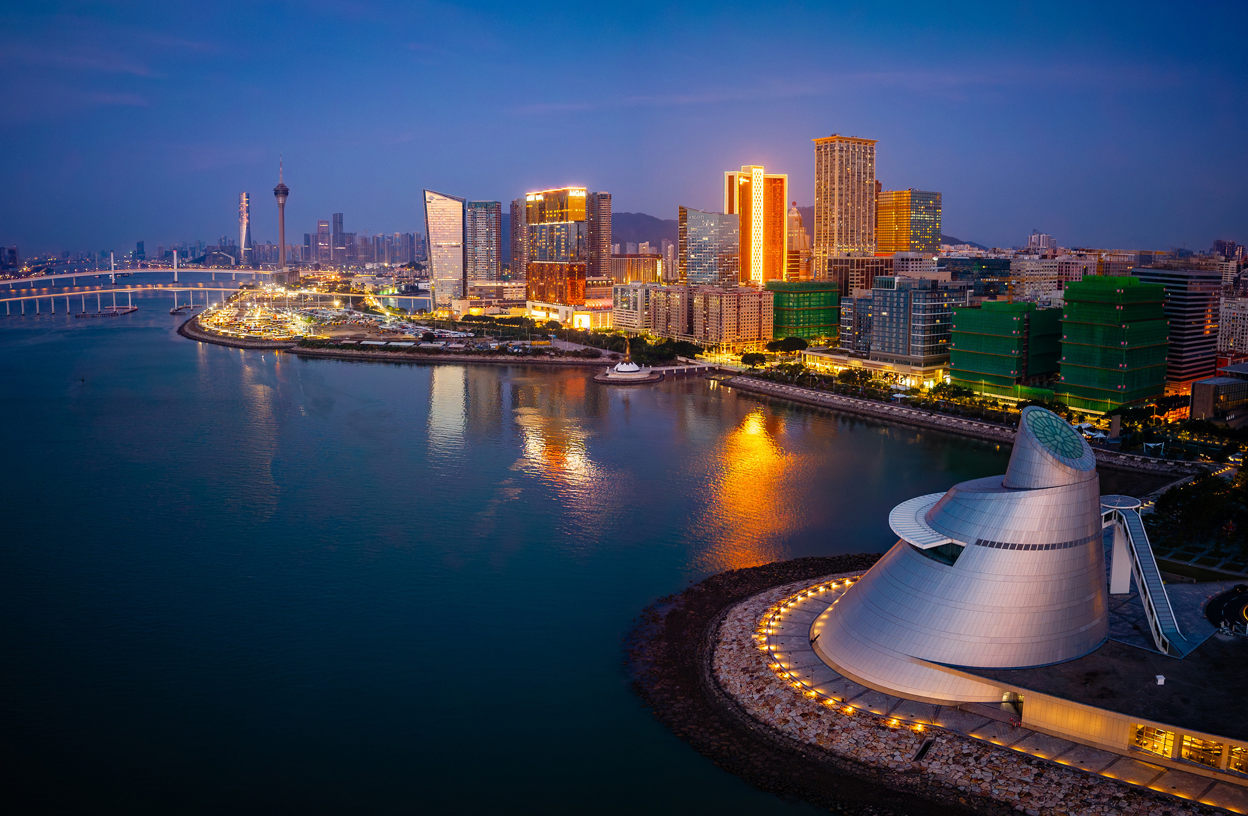 澳门天际线的晨昏韵律，藏着城市的双面魅力。蓝调时刻，澳门塔与玻璃幕墙建筑群在水面