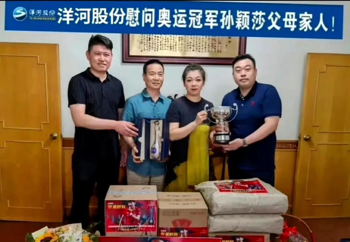 莎莎爸爸妈妈拿着奖杯合照！这是21岁的莎莎获得的奖杯，小小的奖杯比莎莎的的脑袋