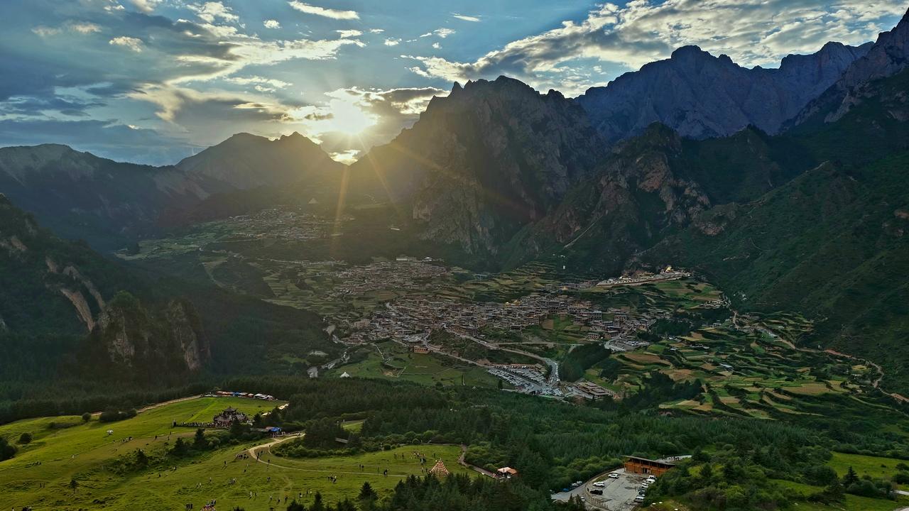 扎尕那藏在甘南的深山里头，四周全是大山围着，把一座座藏式小村子圈在山谷当中。山间