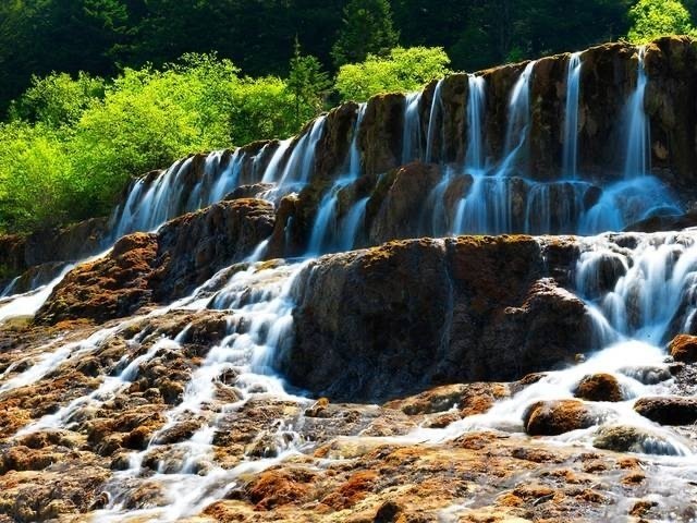 黄龙，被誉为“人间瑶池”；栈道的尽头是黄龙寺，远处便是绵延雪山，云雾缭绕，如入仙
