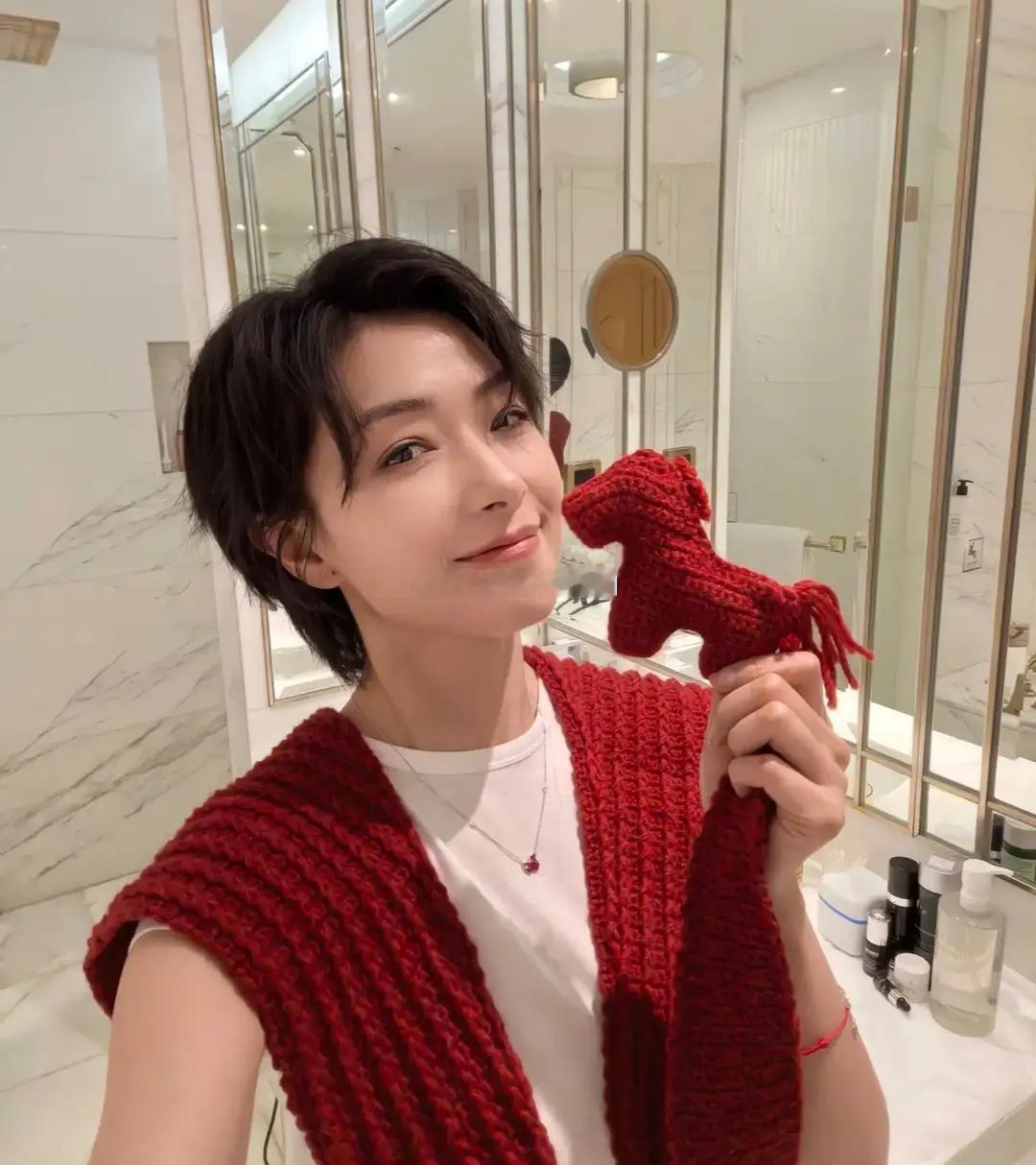 万茜身着皮短裙搭配皮靴，颈间围着妈妈新织的红色披肩围巾，利落中透着温暖，时髦又亮