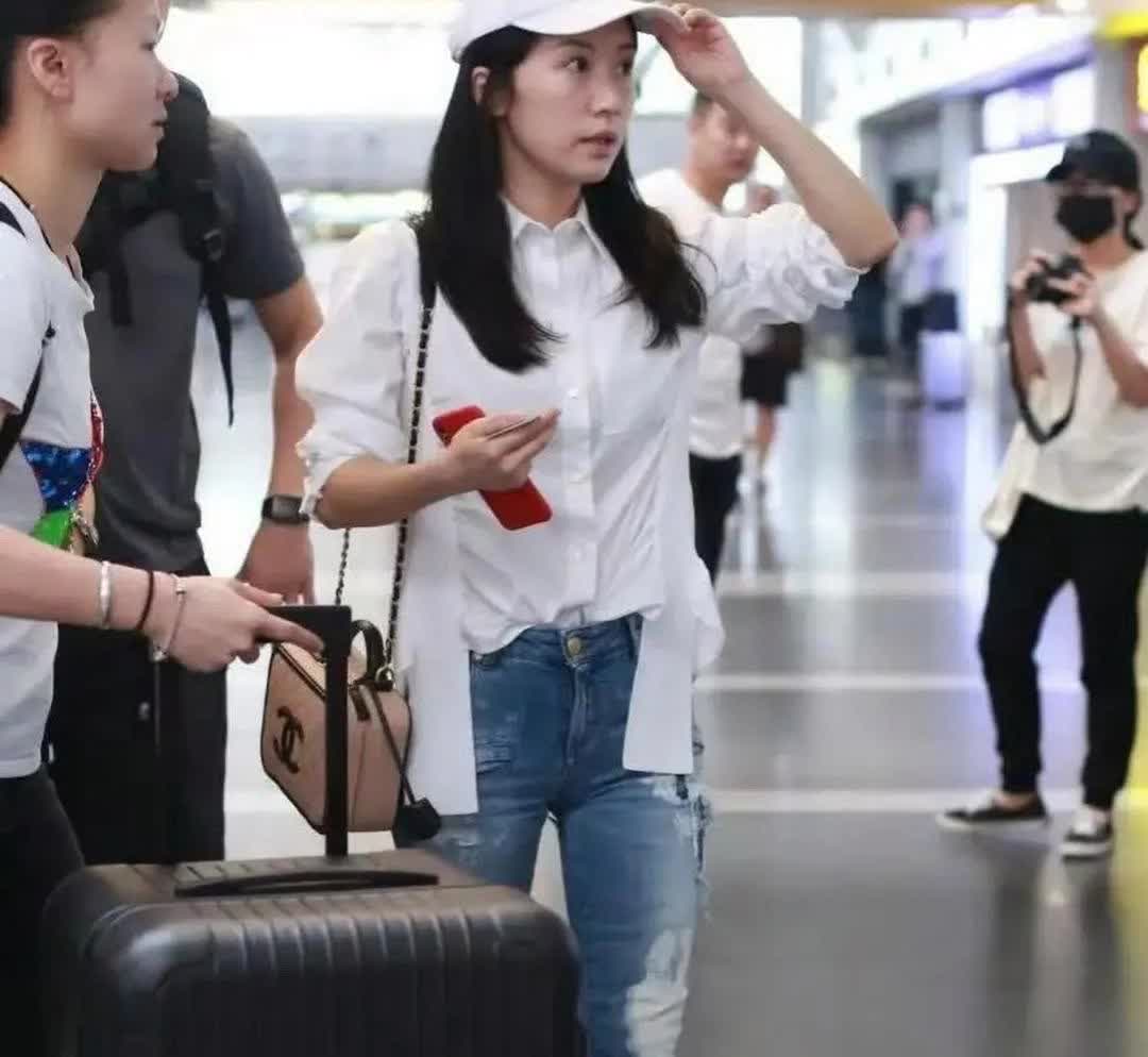 家人们呐，快听好啦！富婆李念生完三胎后现身机场咯👏她一身牛仔裤配白衬衫的装扮