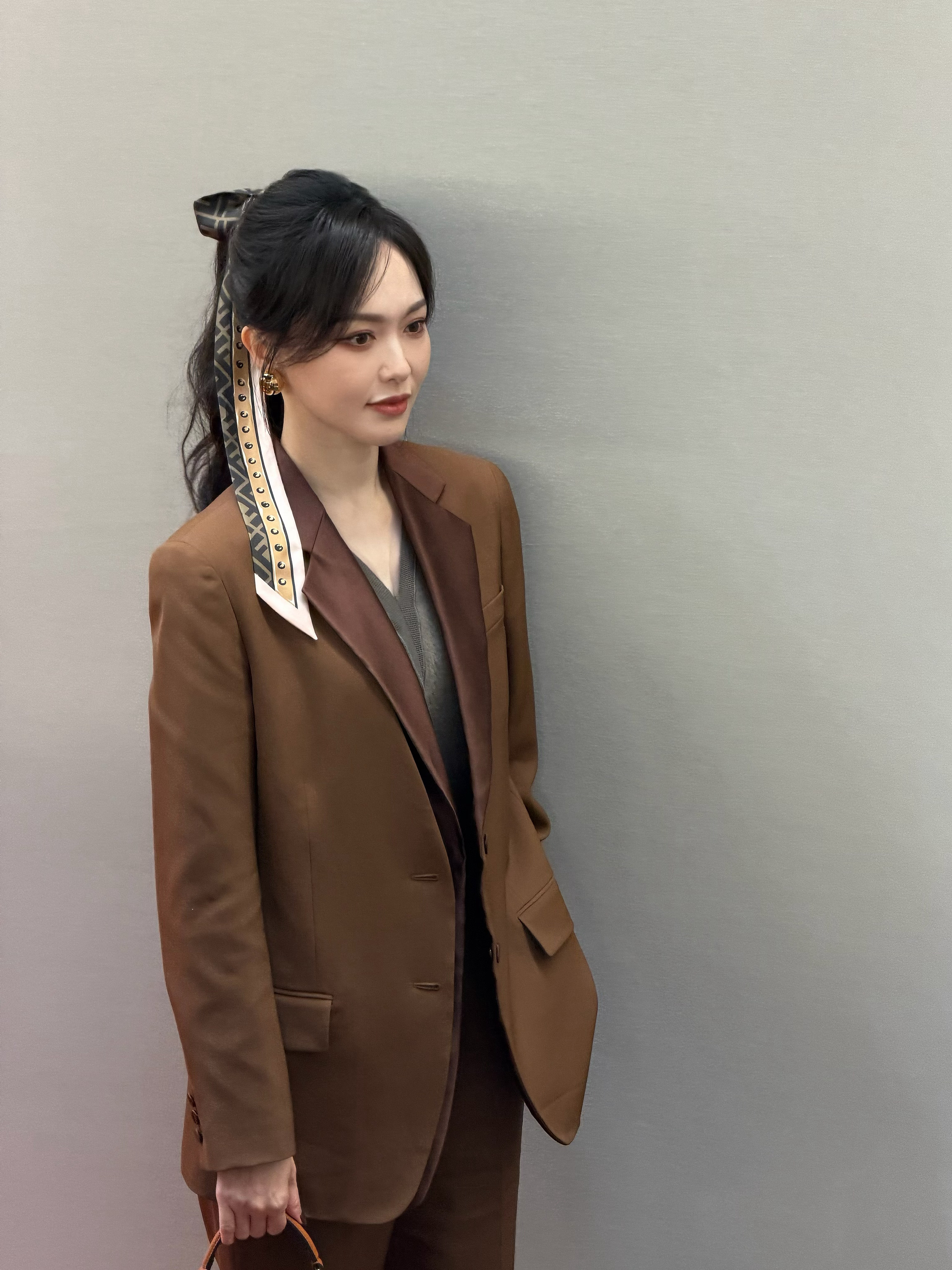 米兰时装周看秀现场路透曝光，面对媒体笑容明媚，一身美拉德色系套装尽显优雅温婉气质