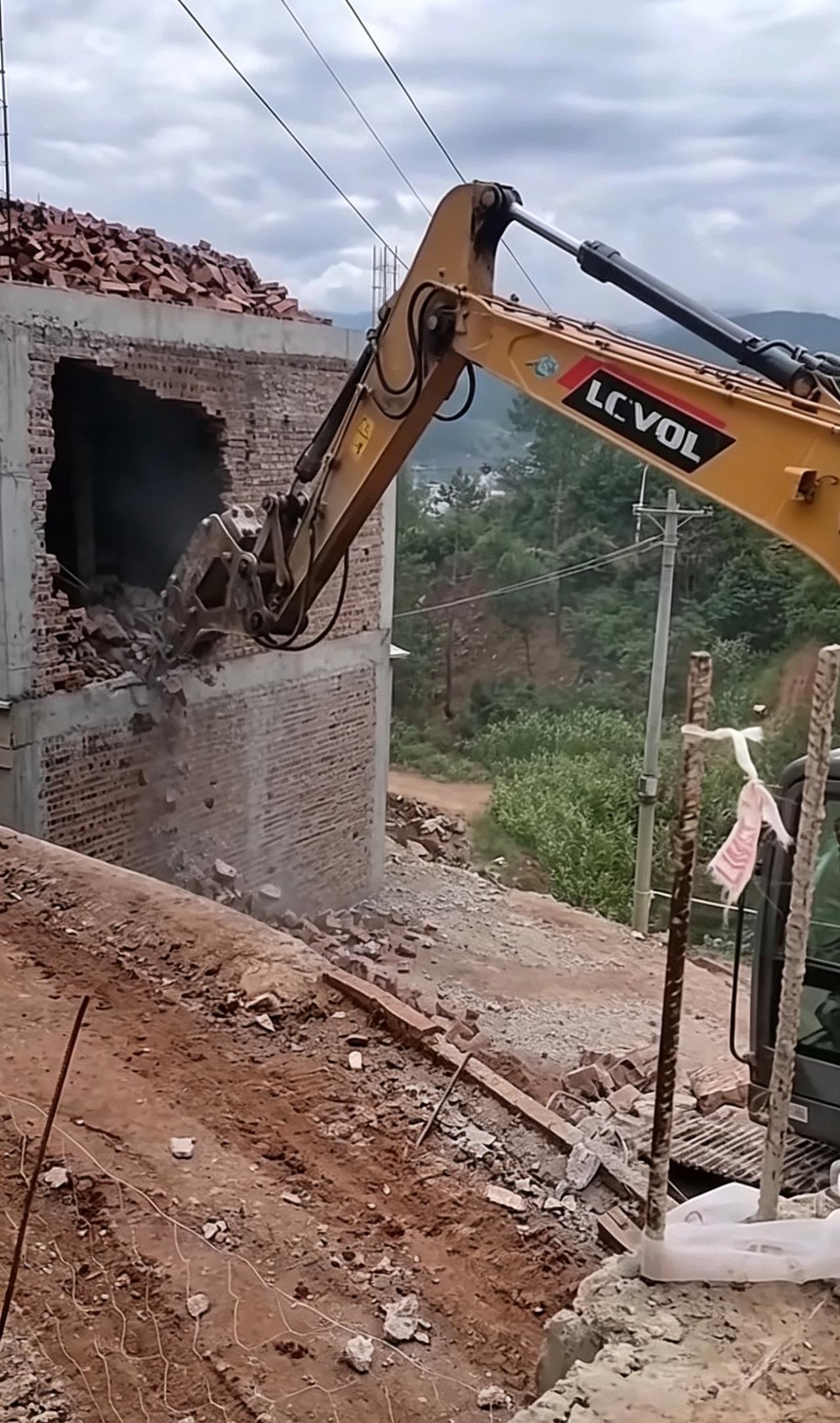 房子建到三层被拆，真的是上方高压线的缘故吗？山边这栋自建房，三层的砖块都已经运