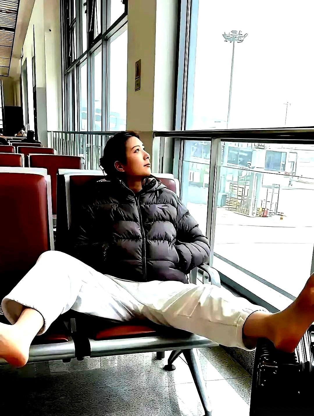 成都机场候机大厅，一个姑娘安安静静地坐着，周围是打电话的、刷手机的、哄孩子的。