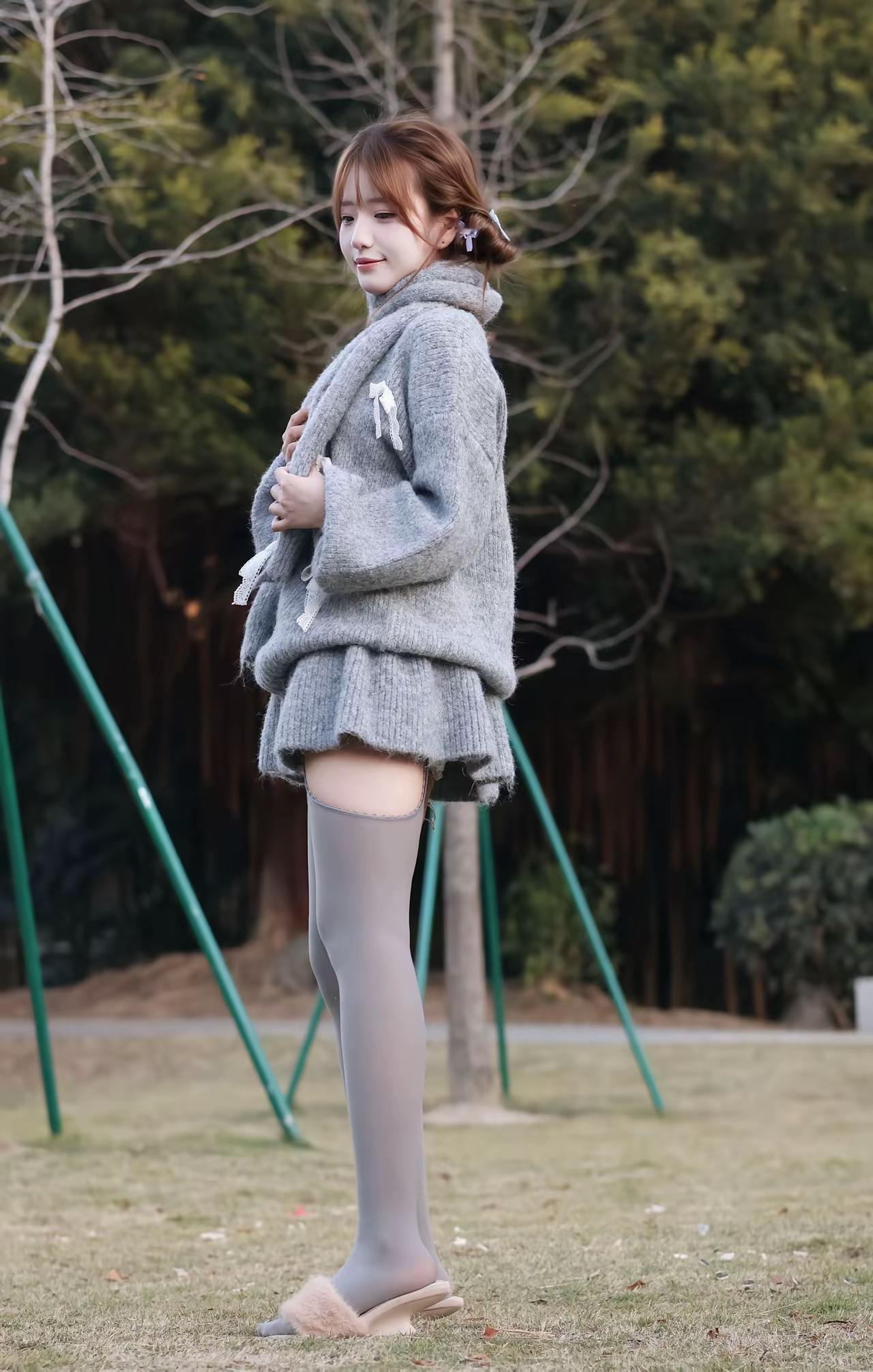 冬日暖阳下，温柔少女漫步在公园里，灰色毛衣与粉色发卡相得益彰，尽显冬日浪漫。