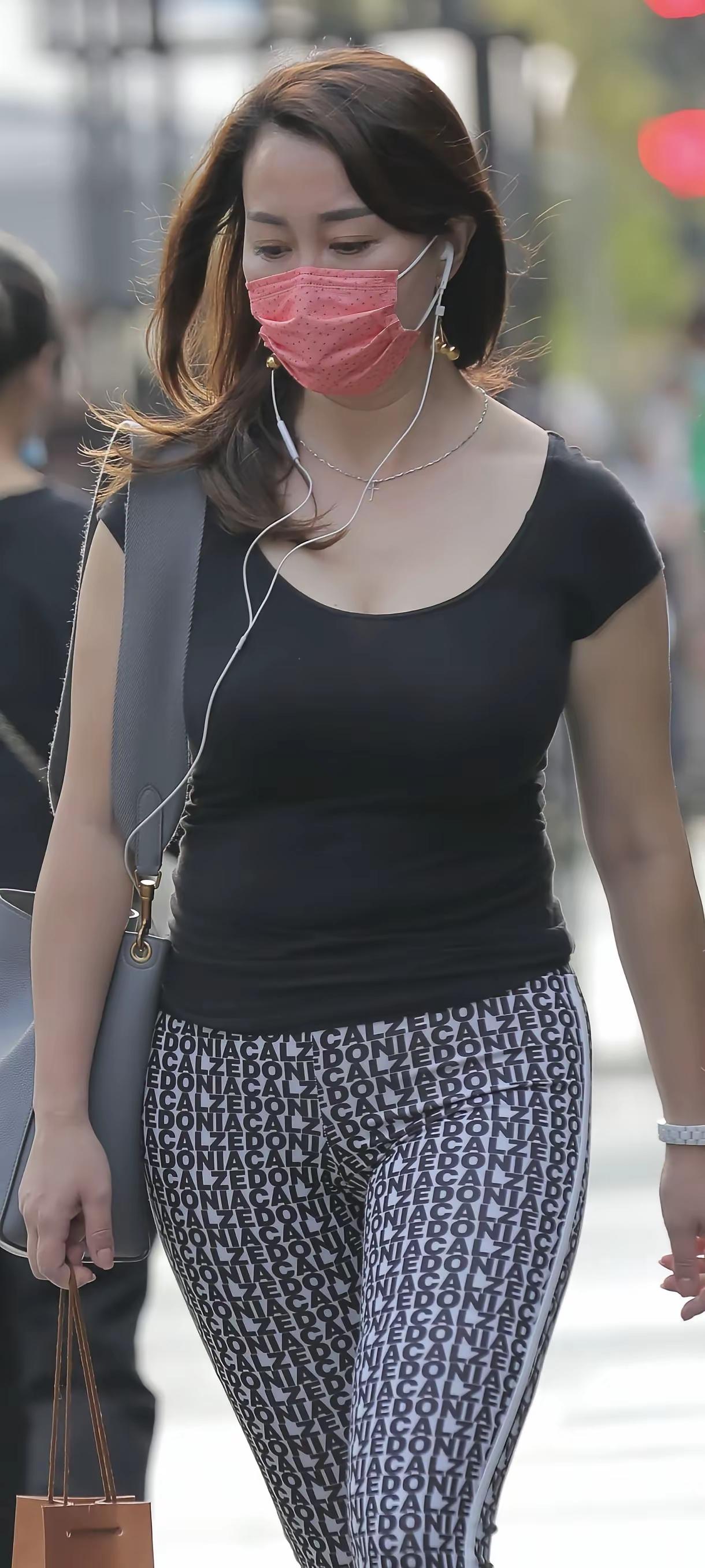 戴口罩的女士在街头散步。