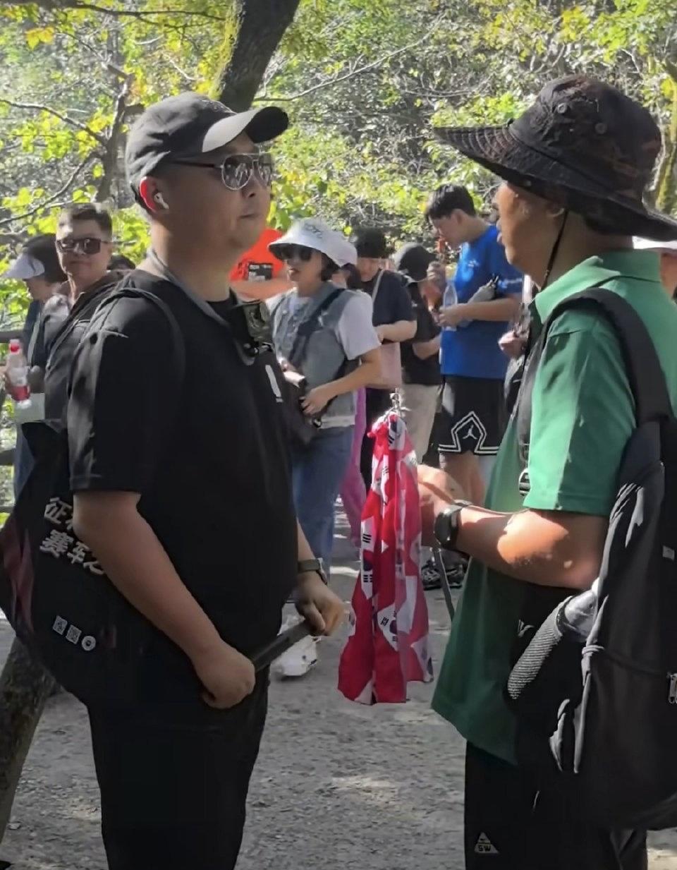 张家界天门山景区，一位韩国导游在带团游玩时，举着带有韩国国旗元素的队旗，结果被现