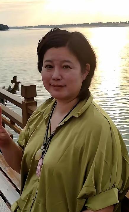要是没人提醒，打死我也不敢信。眼前这个挤着眼睛、双下巴隐约显露的短发大姐，谁能联