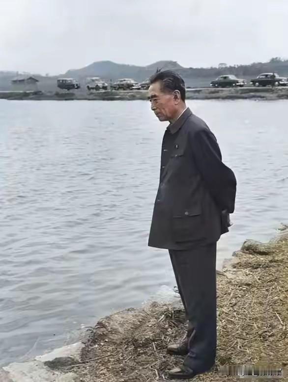 这张照片里的周恩来总理，背着手站在水边，目光低垂、神情凝重，仿佛正陷入深深的沉思