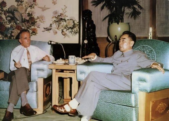 1960年，周总理身穿灰中山装、脚踩凉鞋坐在沙发上侃侃而谈。英国记者格林手拿稿子