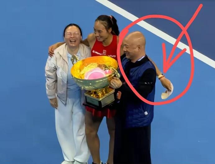 在中网夺冠合影时，郑钦文突然一把薅掉老爸的帽子！原来是老妈在旁悄悄提醒，老爸戴的