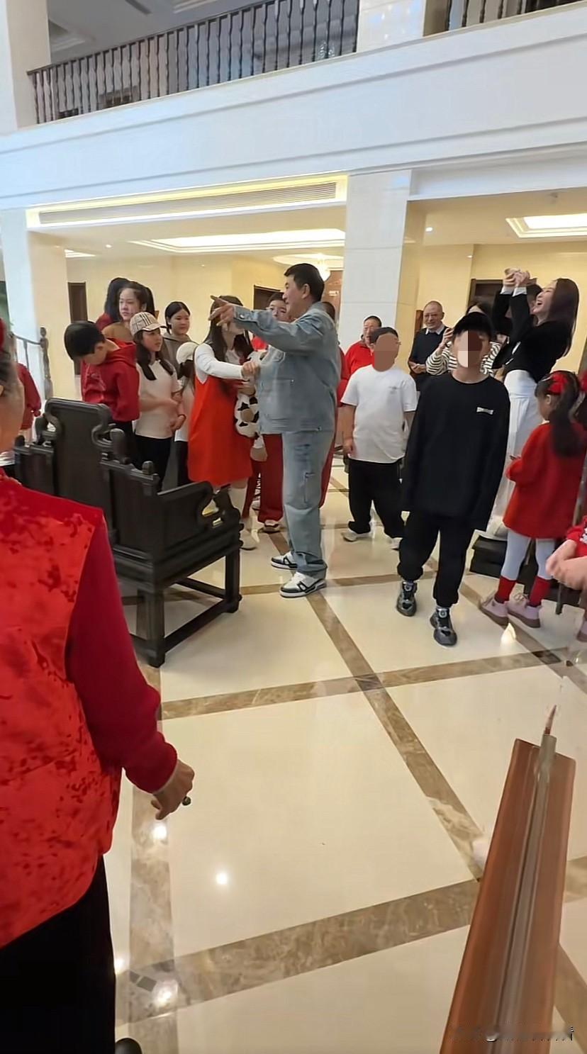 杨子家过年真是热闹，全是一波波要红包的小孩，一群孩子都要向杨子磕头，杨子坐在椅子