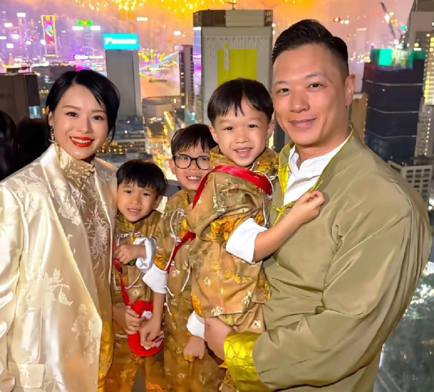 胡杏儿晒出的这张全家福照片中，胡杏儿身处香港高空豪宅露台，背后是维港漫天绽放的