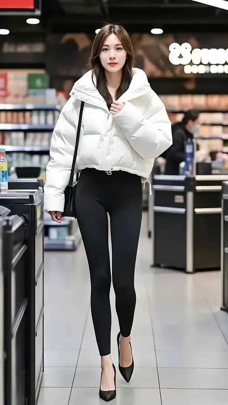 白色的短款羽绒服，保暖有时尚清新，黑色的修身裤搭配黑色的高跟鞋，拉长了腿部线条，