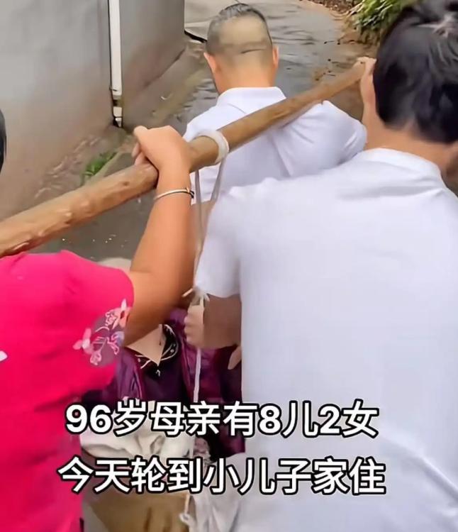 93岁老太太，8儿2女，这次轮到小儿子家住，小两口找来扁担和竹箩筐，一前一后把老